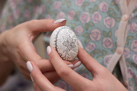 Young woman painting Easter eggs whiteの写真素材