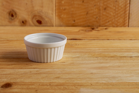 white ceramic bowl on wooden tableの写真素材