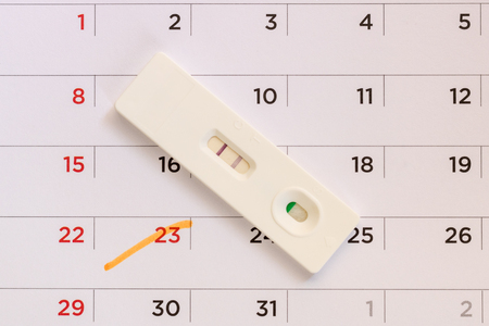 Pregnancy test on calendar background. Pregnancy care concept.の写真素材