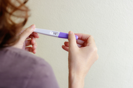 Woman holding pregnancy test, New life and family planning concept.の写真素材