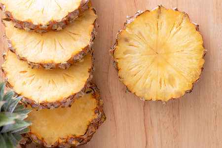 Close-Up of Pineapple slice with the knife on the wooden table