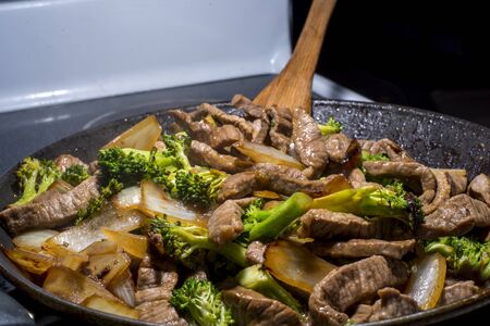 beef broccoli and onion stirfry steaming in a panの写真素材
