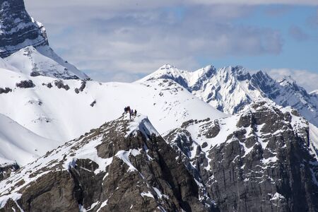Group of hikers on top of snowy mountain peak in Canadian Rockiesの写真素材