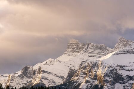 Morning clouds above a snowy mountain peak