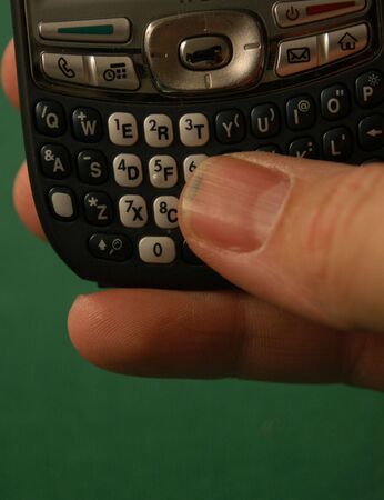 Thumb on the keypad of a smart phone の写真素材
