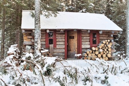 A log cabin in the woods during the winter seasoの写真素材