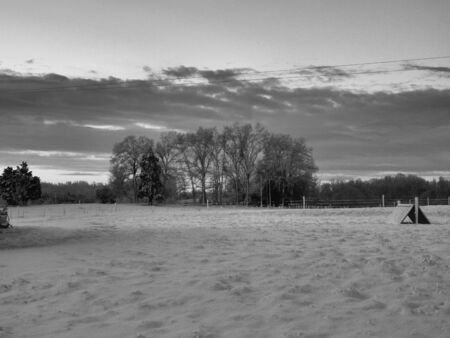 a farm in winter shown in black and whiteの写真素材