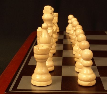 chess pieces lined up and ready for the start of a matchの写真素材