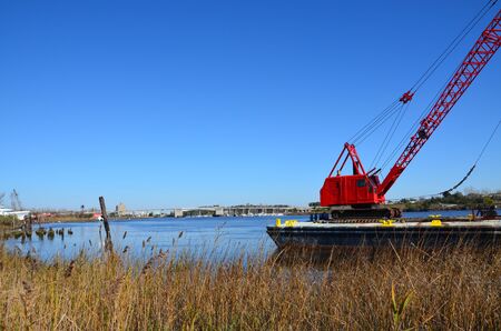 Red crane along the shore to do some heavy lifting