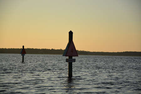 Sunset on the river with channel markers showingの写真素材