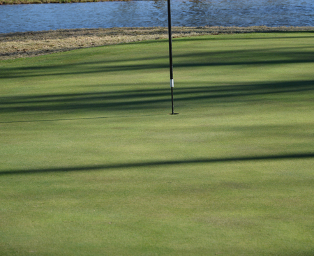 Near the flag on a golf course during the fall of the year. の写真素材