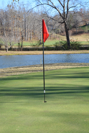 Near the flag on a golf course during the fall of the year. の写真素材