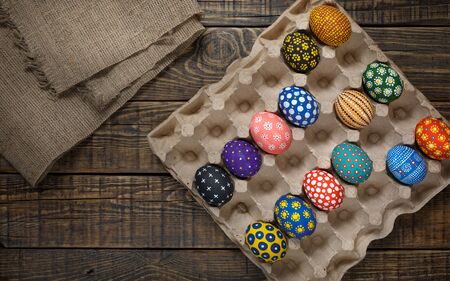 Colorful Easter eggs in handmade on wooden background text to a sackclothの写真素材