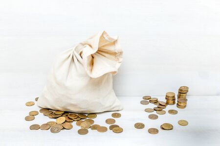 Money bag and gold coins on white wooden backgroundの写真素材