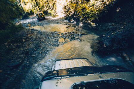 SUV cross the mountain river in forest. View from the hatch of the car. Tourist expedition Gelendzhik, Russiaの写真素材