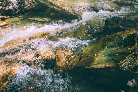 Large stones in the rugged mountain river. Water landscape close-upの写真素材