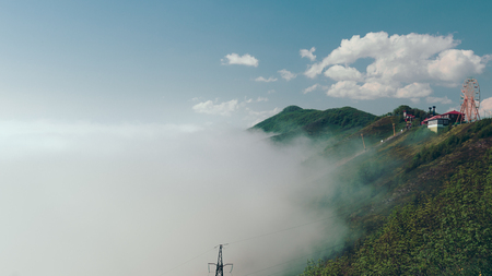 Stunning mountain scenery and green fields with a cableway.の写真素材