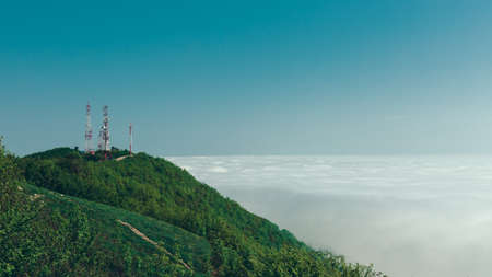 Telecommunication towers on top of a mountain against a background of clouds and fog. Mountain landscape. Gelendzhik, North Caucasus, Russiaの写真素材