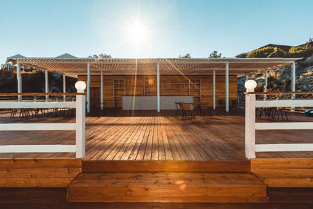 Wooden terrace with view on sea and sunset resortの写真素材