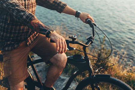 Unrecognizable Young Man Standing With Bike On Coast And Enjoying View of Nature Sunset Vacation Traveling Relaxation Resting Conceptの写真素材