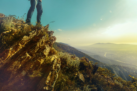 Pair of human feet stands on top of  mountain against  background of  sunny valley. Concept of travel, adventure and discoveryの写真素材