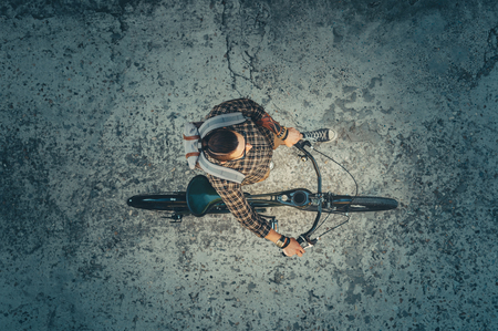 Young Guy Cyclist Riding On Bike Down The Street, Top View. Daily Lifestyle Urban Resting Conceptの写真素材