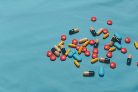 Different Colorful Pills, Tablets And Capsules On Blue Backgroundの写真素材
