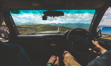Happy Couple Driving In Car and Holding Hands, Rear View. Road Trip Adventure Conceptの写真素材