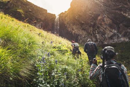 Group Of Tourists Walking Uphill To Waterfall. Travel Adventure Outdoor Conceptの写真素材