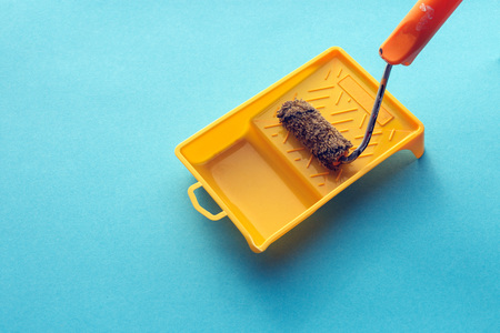 Roller For Paint And Painting Capacy On Blue Background Surface. Home Repair Creativity Conceptの写真素材