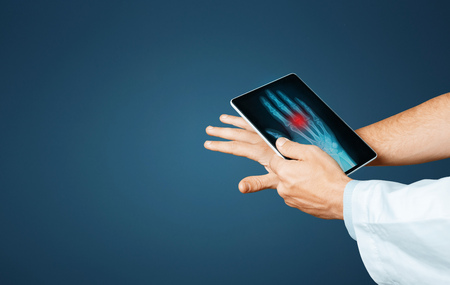 Doctor With Digital Tablet Scans Patient Arm, Modern X-Ray Technologists In Medicine And Healthcare...