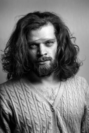 Portrait Of handsome stylish man with a beard, long hair and big blue eyesの写真素材