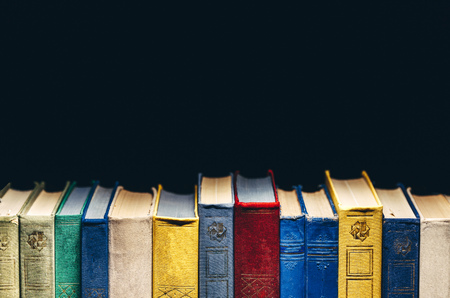 Old Books In A Row In Library On Black Background With Copy-Spaceの写真素材