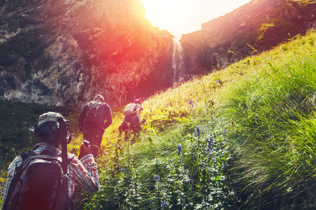 Group Of Hikers Tourists Walking Uphill To Waterfall. Travel Adventure Outdoor Conceptの写真素材