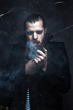 Brutal Sailor Man With Beard Smoking Pipe. CreativÑ Professional Portrait Toned With Scratchesの写真素材