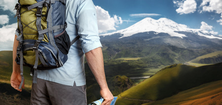 Unrecognizable Male Traveler With A Backpack Looking Into The Distance Mountains, Rear View. Adventure Destination Conceptの写真素材