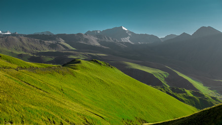 Picturesque Green Mountain Landscape At Dawn In Blue Sky. Green Field And Blue Sky. Tourism Travel Conceptの写真素材