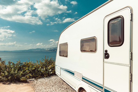 Caravan Trailer Near Sea, Beach And Blue Sky. Summer Holidays Road Trip Travel Conceptの写真素材