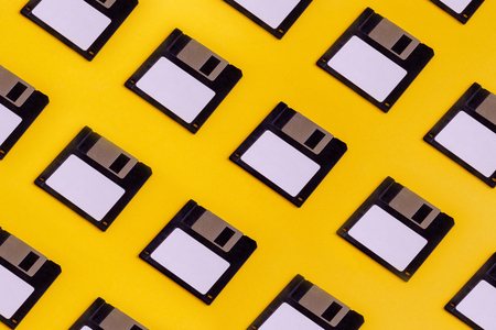 Floppy Data Storage Diskettes On Yellow Background. Old Retro Technologyの写真素材