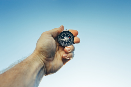 Man Scout Explorer Searching Direction With Compass On Blue Sky Background, Point Of View Shotの写真素材