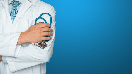 Doctor with stethoscope on blue background. Global concept of medicine and healthcareの写真素材