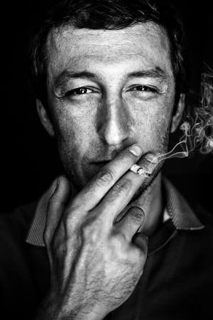 Happy man smokes a cigaretteの写真素材