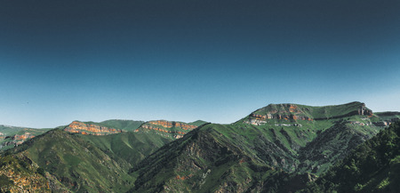 Picturesque mountain landscape of the North Caucasus, Russia. Green hills against blue sky. Concept of adventure, travel, wanderlustの写真素材