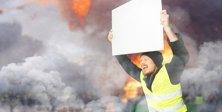 Protests yellow vests. A young man is holding a poster. The concept of revolution and protest, the struggle for equal rights, the electoral movementの写真素材