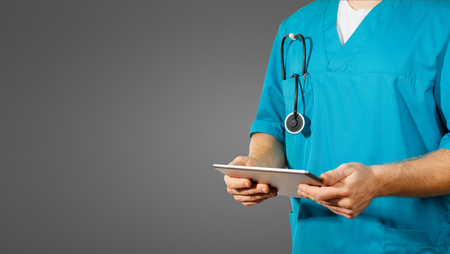 Concept of global medicine and healthcare. Doctor holds digital tablet. Diagnostics and modern technology on black backgroundの写真素材