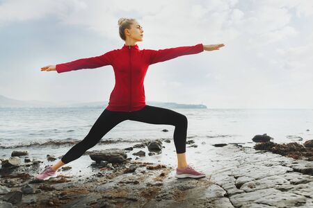 Young Attrective Woman Practicing Yoga On The Beach. Biohacking, Meditation, Mental Health Conceptの写真素材