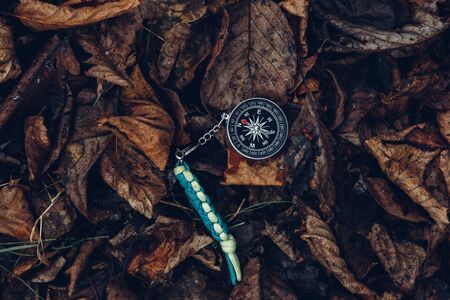 Compass On Leaves In The Forest, Metaphor. Bushcraft Equipment Survival Scouting Conceptの写真素材
