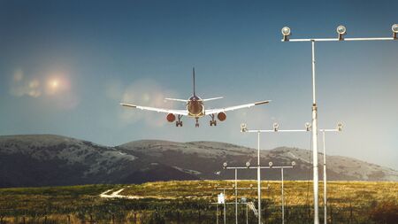 Airplane Lands At The Airport Against Backdrop Of Picturesque Mountain Landscape. Travel And Tourism Conceptの写真素材