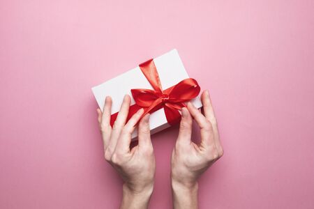 Unrecognizable Female Hands Packed Gift For Valentines Day On Pink Background, Top Viewの写真素材