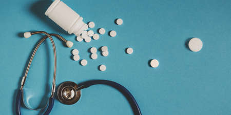 White Pills, Bottle And Stethoscope On Blue Background, Top View. Medicine Healthcare Pharmacyの写真素材